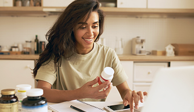 Female looking at vitamins at home 394x229